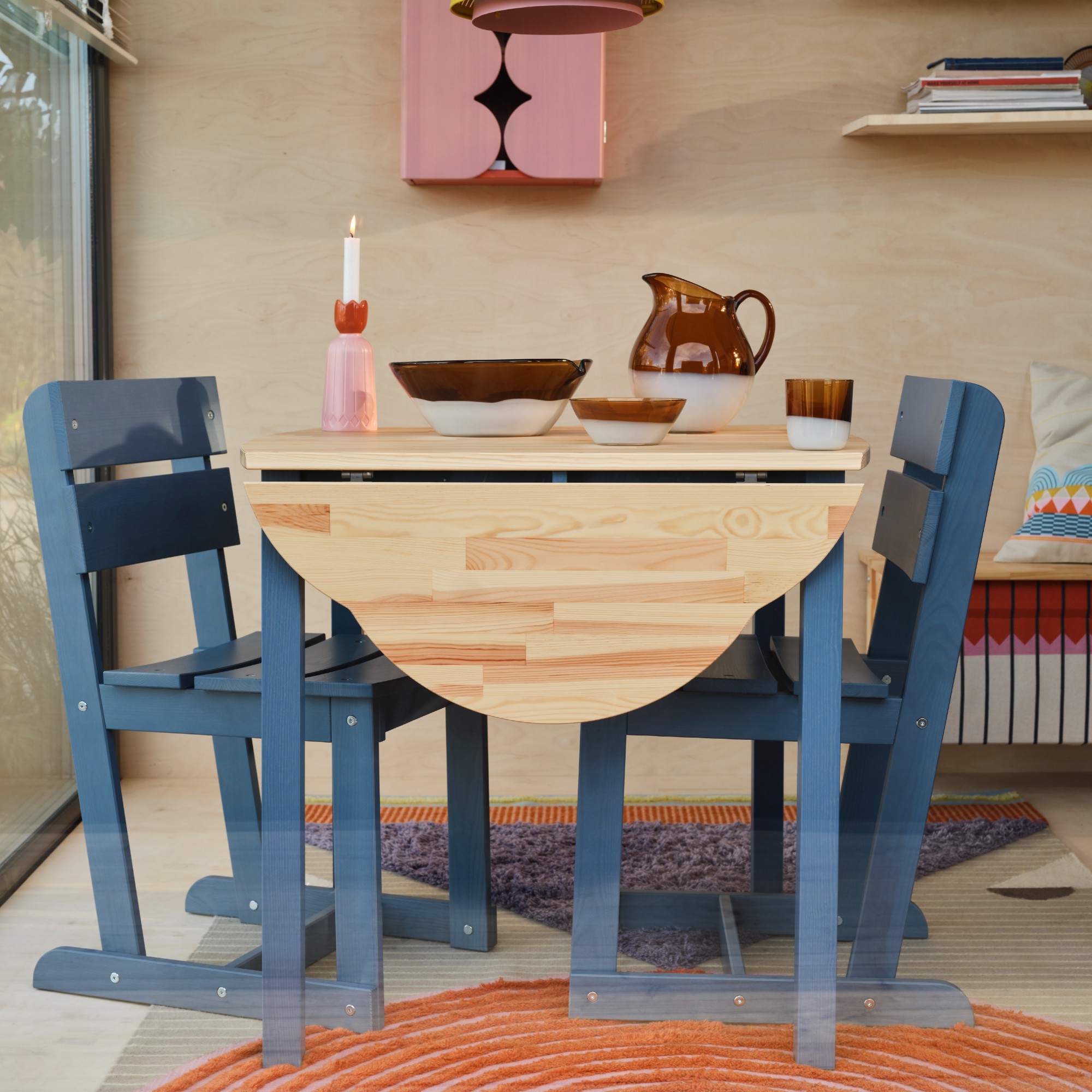 A dining area with a drop leaf table and matching blue chairs from the IKEA OMMJ&amp;Auml;NGE collection