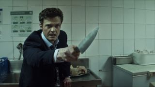 Jack Quaid holding a knife in Novocaine