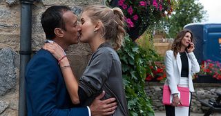 Behind the Woolpack, Holly Barton and Jai Sharma are kissing when they hear Megan Macey approaching. They jump apart but is their secret out in Emmerdale.