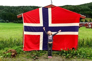 A young fan awaits the Arctic Race of Norway peloton to pass by
