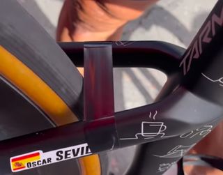 A close up of Oscar Sevilla's Specialized Tarmac, showing electrical tape on the seat stays next to the rear tyre to brush away gravel. Sevilla's name tag shows on the outside of the stay