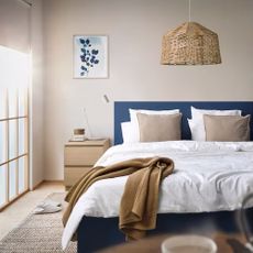 A bedroom with cream walls and a blue bed frame