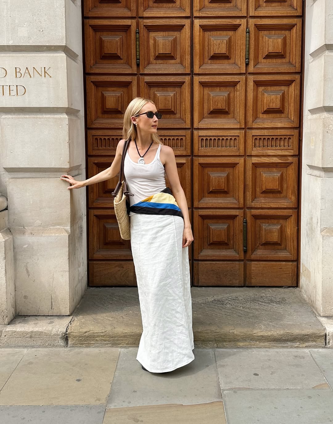 @chloekathbutler wears a white tank top, skirt, coliurful scarf and necklace