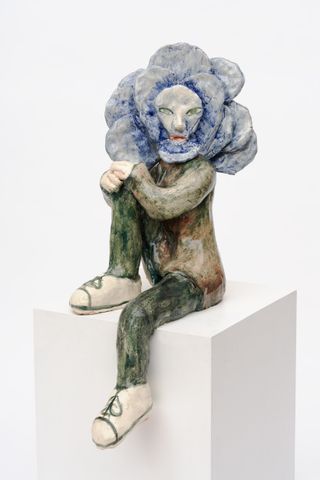 Sculpture of a woman with her face as the centre of a flower
