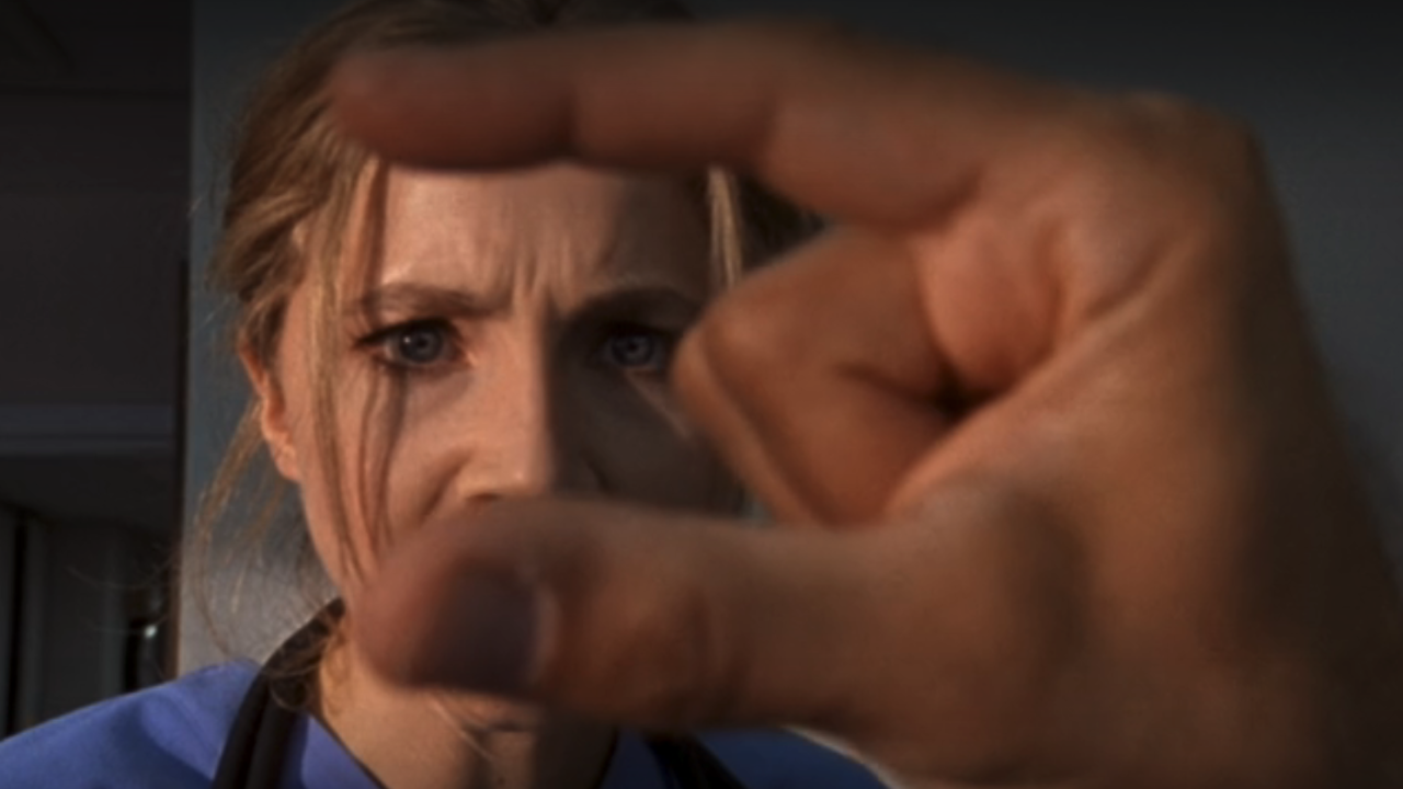 Sarah Chalke schaut sich die Handarbeit an 