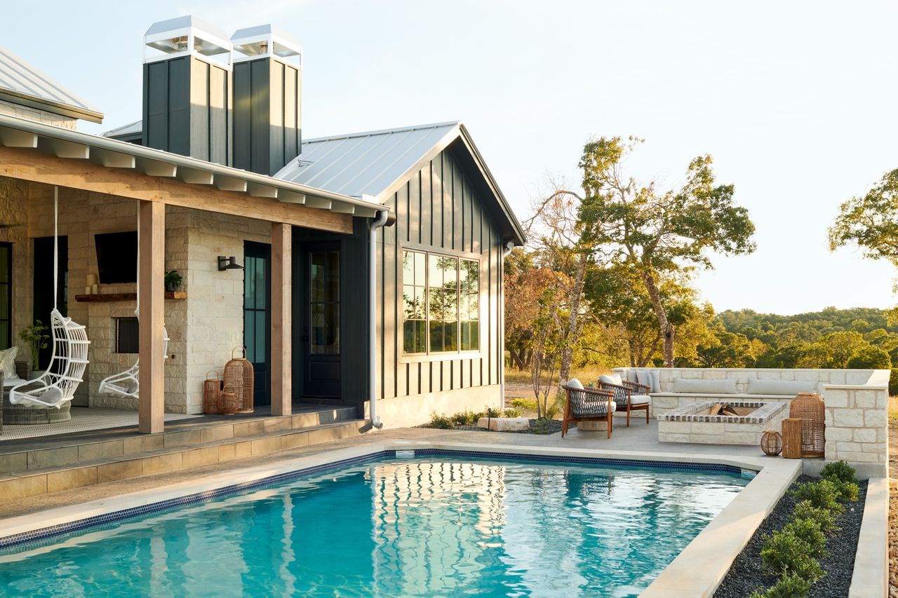 backyard with pool, fire pit and swing chairs by LH. Designs