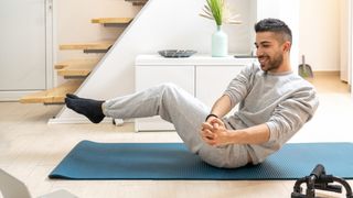 Man doing Russian twists in living room