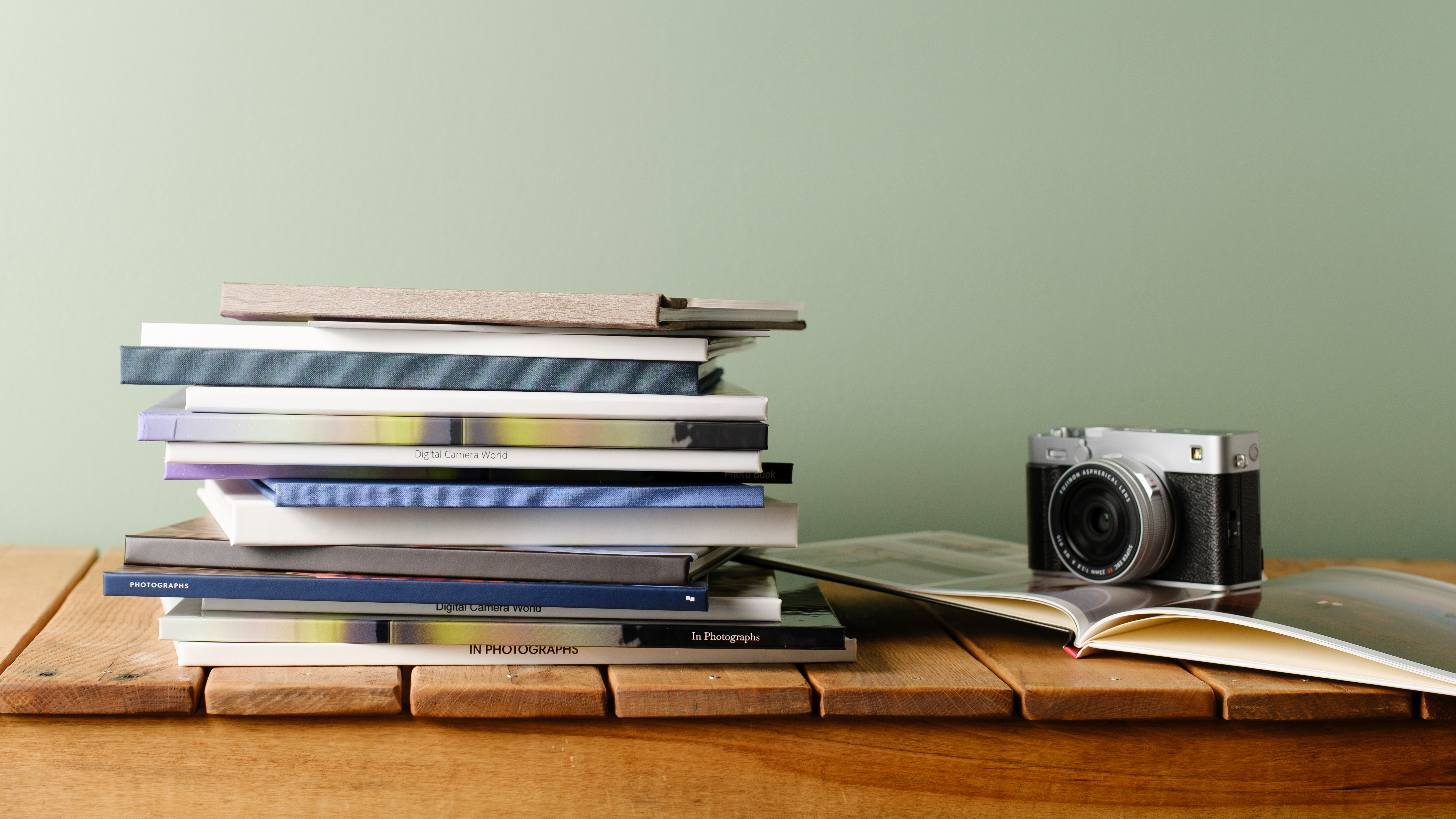 A stack of various photo books on a desk