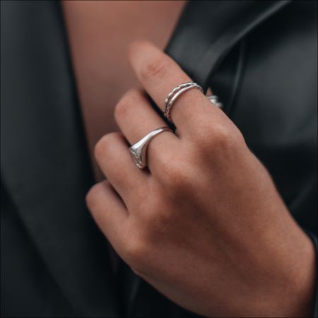 Female Hands In A Black Stylish Leather Jacket And Silver Accessories On A Female Body. - stock photo