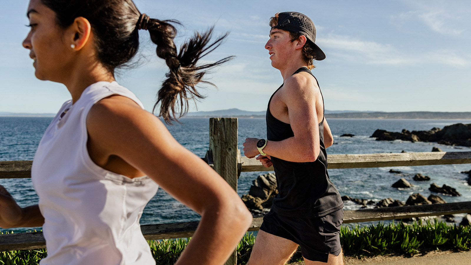 Two runners exercising in the sunshine wearing Garmin watches
