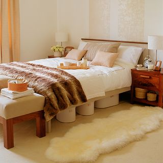 bedroom with tonal faux fur runner on the floor and tip boxes under the bed