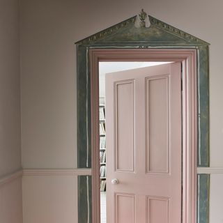 Pale pink hallway with pale pink internal door with grey framing painted around it