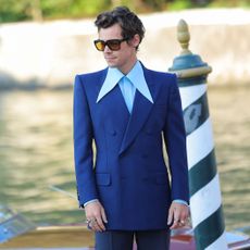 Harry Styles wearing a blue suit and sunglasses