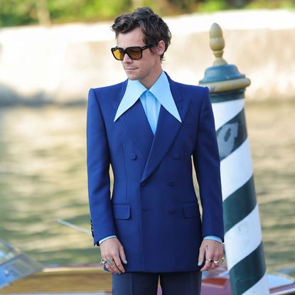 Harry Styles wearing a blue suit and sunglasses