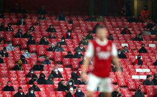 Arsenal fans watch from the stands during a Premier League match at the Emirates Stadium