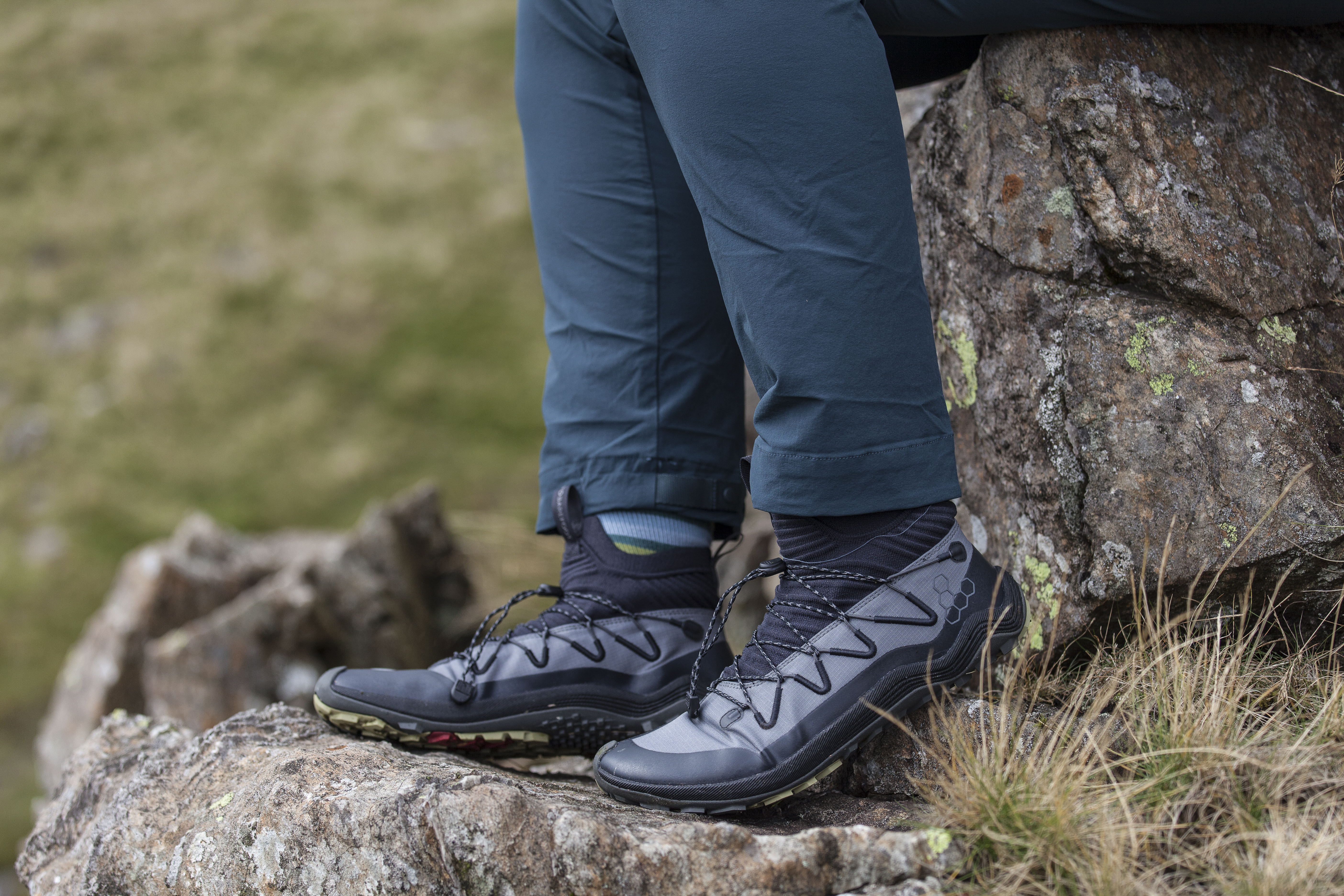 Woman wearing Vivobarefoot Primus Flow Mid hiking boots and scrambling in them