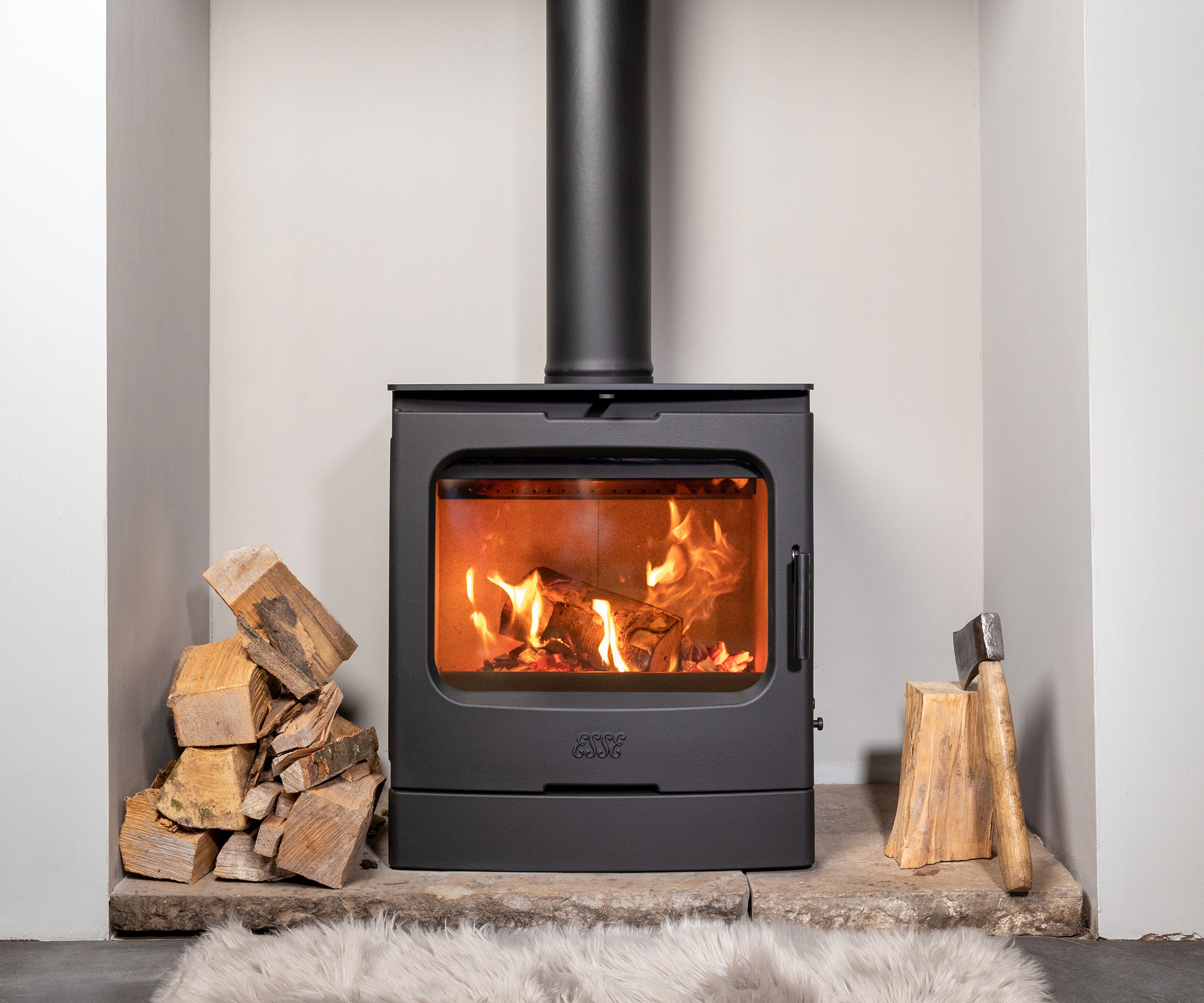 modern black log burning stove in hole in the wall fireplace
