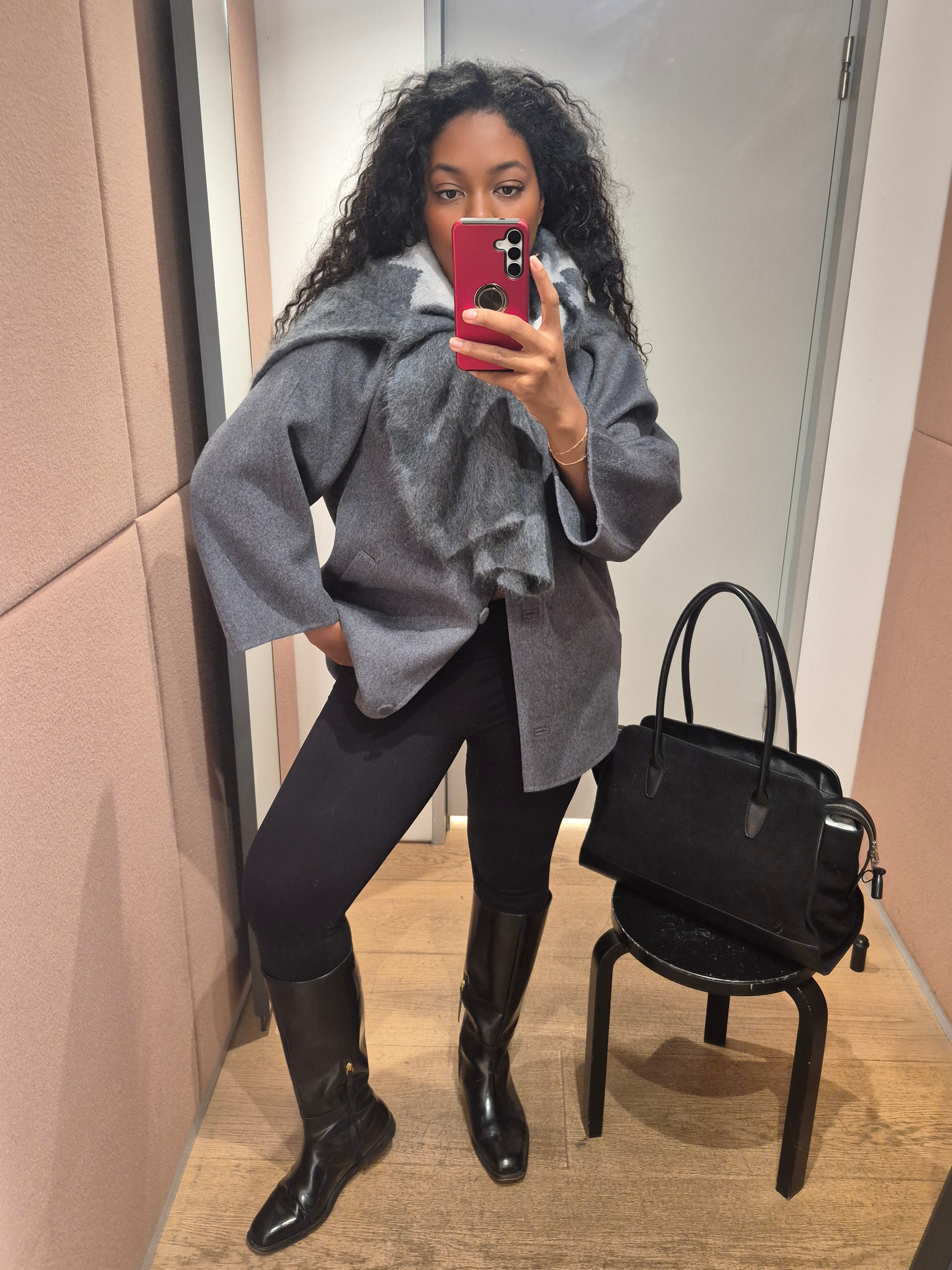 Remy Farrell wears leggings, knee high boots and a grey cashmere knit and coat.