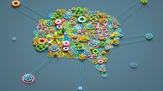 Digital generated image of multi coloured gear wheels connected together in shape of brain on grey background.