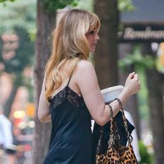 Jennifer Lawrence channels lingerie dressing in a lacy black slip dress and house slippers.