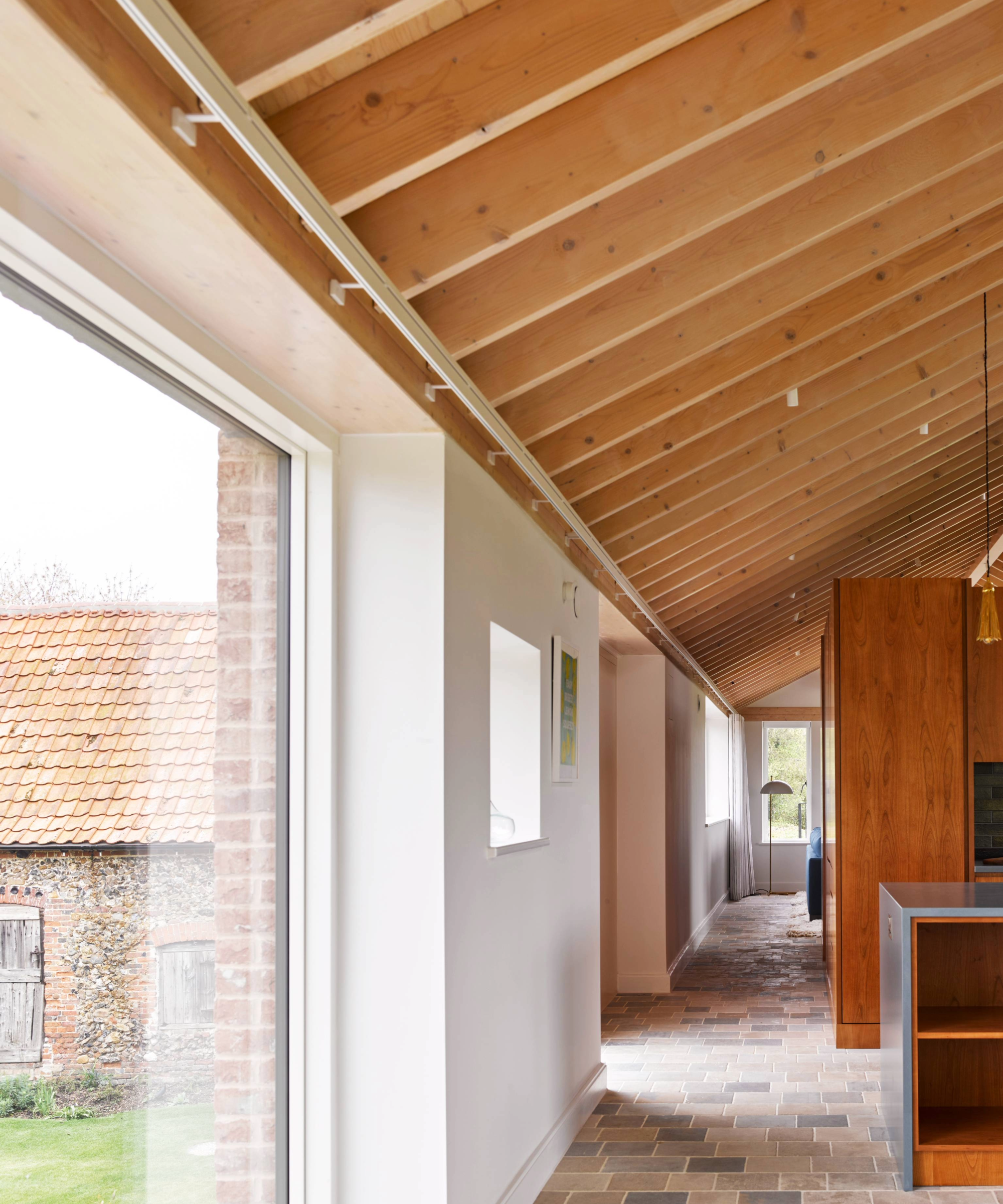 Hallway with the kitchen on the right and large windows on the left