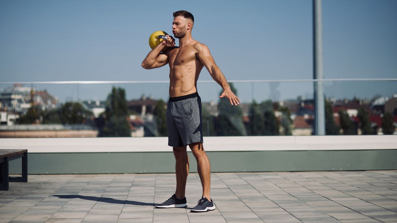 Man exercising with a kettlebell outside