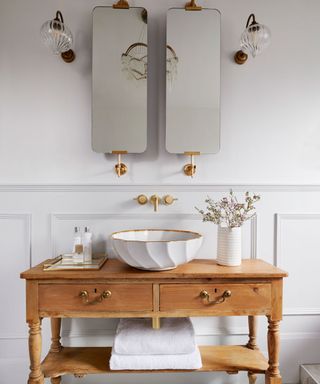 bathroom with table and washstand and mirrors and towels