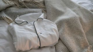 A pair of folded pyjamas on a bed