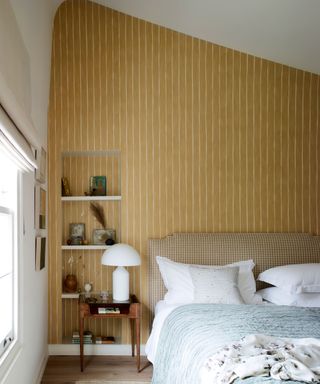 bedroom with ochre striped wallpaper in Victorian mews house in London with contemporary interior designed by Kitesgrove