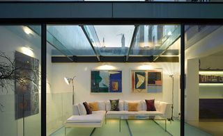 A listed London home has been extended in glass, creating a contemporary living area above a new basement studio