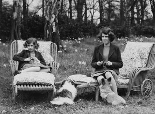 Princess Elizabeth and Princess Margaret knitting for the forces in the grounds of the Royal Lodge in Windsor Great Park