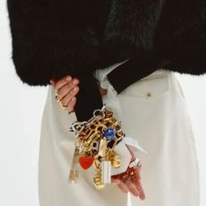 a model wearing a stack of celine charm bracelets