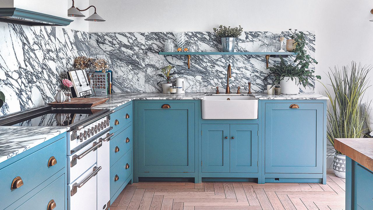 Blue shaker kitchen with butlers sink and marble backsplash.