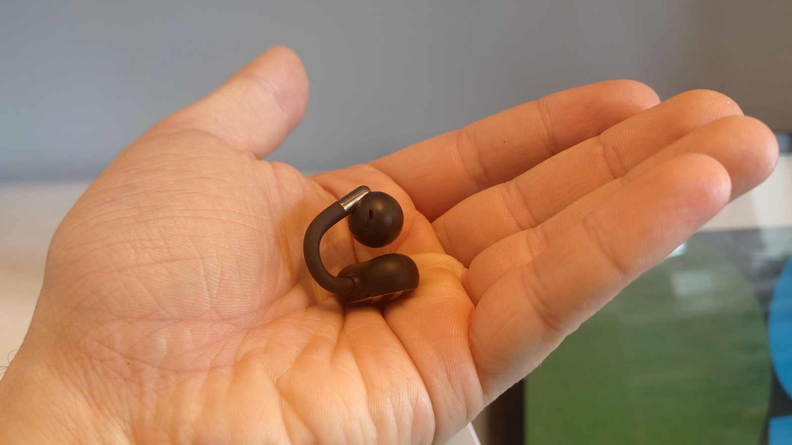 A single Soundpeats Clip1 bud in a hand.