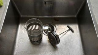 A French press soaking in the sink