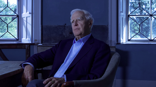 Bestselling spy novel author John le Carré sits in a darkened study in a scene from new Apple TV Plus documentary The Pigeon Tunnel.