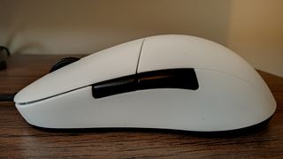 A white Endgame Gear XM1r gaming mouse on a wooden table