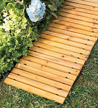 A temporary wooden slat garden path on a lawn
