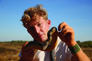 Northern Territory Australia - Jack Randall poses with a Water Python, one of six types of pythons found in Australia's Northern Territory