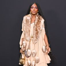 Doechii wearing braids and a bright blush color posing in front of the camera