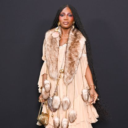 Doechii wearing braids and a bright blush color posing in front of the camera