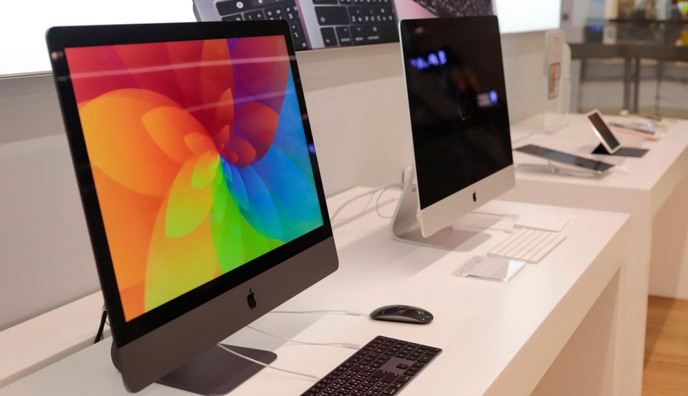 Two iMac models on sale in a retail store.