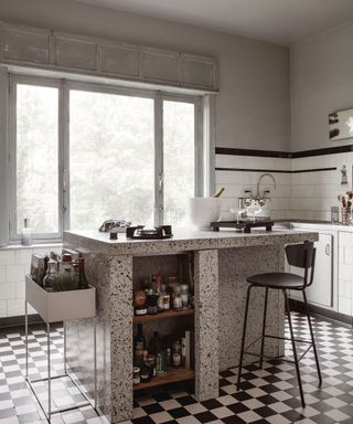A white and grey kitchen with black and white checkered flooring, Terrazzo island