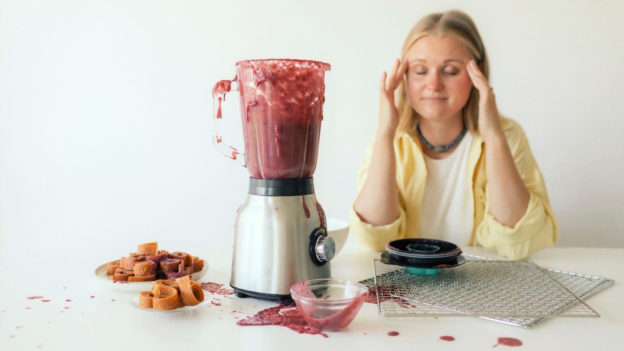Close-up of a woman in her kitchen whose blender broke while making homemade fruit puree.