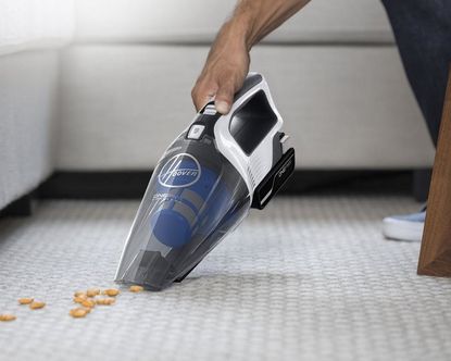 Hoover ONEPWR Cordless Handheld Vacuum picking up snacks