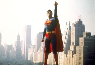 Actor Christopher Reeve poses with one arm up in a still from a Superman film, in 'Super/Man.'