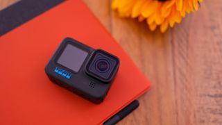 A photo of the GoPro Hero 11 Black on a red background