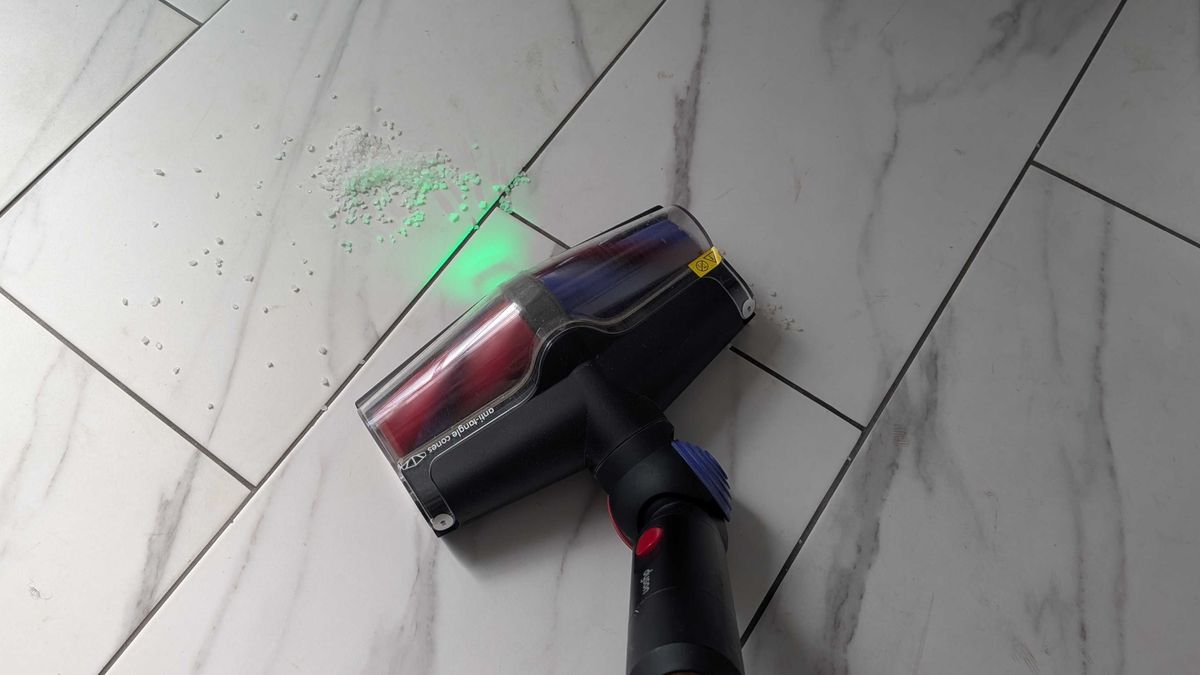 Dyson V16 Animal Piston cleaning debris on the whilte floor tiles