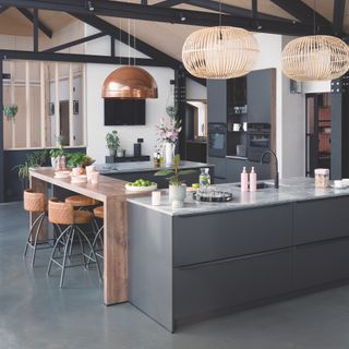 grey kitchen with wood island and concrete flooring