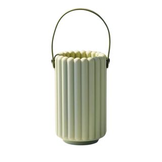 A matcha green, ribbed ceramic cylindrical essential oil diffuser with a handle 